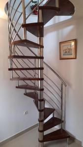 a wooden spiral staircase in a room with a picture at Apartments Lumbarda in Lumbarda