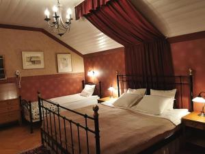 a bedroom with two beds and a chandelier at Ulfshyttans Herrgård, nära Romme Alpin in Borlänge