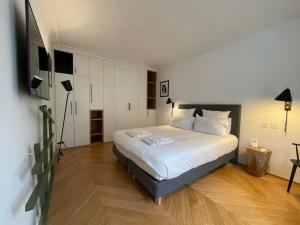 ein Schlafzimmer mit einem großen weißen Bett in einem Zimmer in der Unterkunft RESIDENCES HARCOURT - Ile Saint Louis - PARIS in Paris