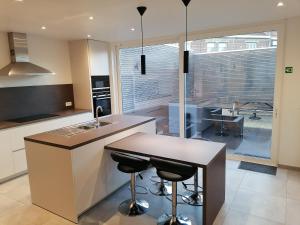 a kitchen with a sink and a counter with stools at The Front Door N28 in Ieper