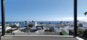 a view of a city with white buildings and the ocean at Villas Vistabella in Puerto del Carmen