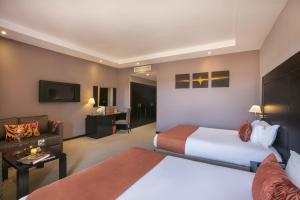 Kech Boutique Hotel & Spa في مراكش: غرفة فندقية بسريرين واريكة