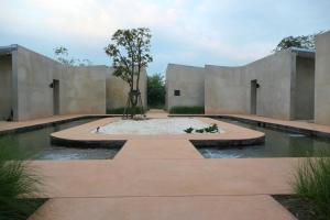 a building with a fountain with a tree in it at Banmon Makok in Ban Makok