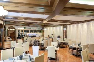 a restaurant with white tables and white chairs at Hotel Weinberg GmbH 