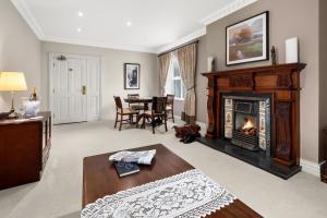 a living room with a fireplace and a table at Rathkeale House Hotel in Limerick