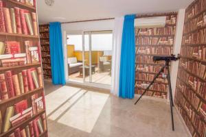 a room with blue curtains and a room with books at Casa Tres Vistas Luxury apartment with stunning views to the ocean in Puerto de Santiago