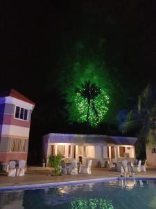 a building with a palm tree with green lights at coral beach resort in Mahabalipuram