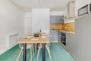 a kitchen with a wooden table and chairs at Le Tyrolien in Eaux-Bonnes