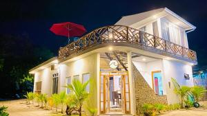 a house with a red umbrella on top of it at String Wave Maldives in Gulhi