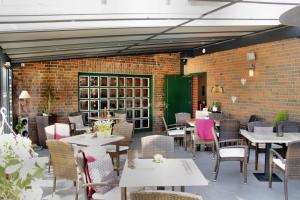 a restaurant with tables and chairs and a brick wall at Landgasthof Köhlbarg in Hanerau-Hademarschen