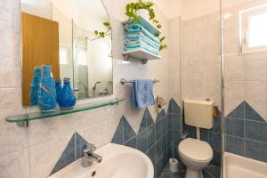 a bathroom with a sink and a toilet and a mirror at Villa Rossa 2 in Tučepi +63 photos