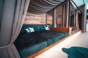 1 dormitorio con 1 cama verde grande con cortinas en Sun Lodge Schladming by Schladming-Appartements en Schladming
