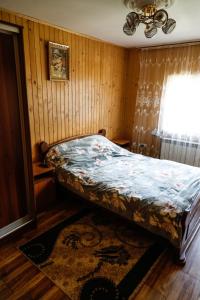 - une chambre avec un lit dans une pièce dotée d'une fenêtre dans l'établissement Домашня Оселя, à Yaremtche