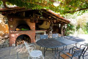 une table et des chaises devant un four en briques dans l'établissement Casa Zafferano, à Albenga