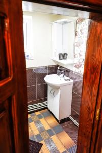La salle de bains est pourvue d'un lavabo et d'un miroir. dans l'établissement Домашня Оселя, à Yaremtche
