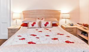 Un dormitorio con una cama con flores rojas. en York Apartment Conway Cottage, en York