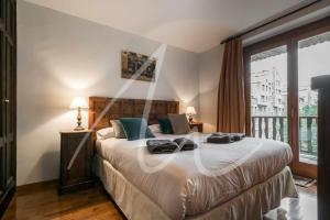 a bedroom with a large bed and a large window at Amitges by SeaMount Rentals in Baqueira-Beret