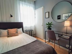 Schlafzimmer mit einem Bett, einem Schreibtisch und einem Spiegel in der Unterkunft Hotell Fängelset Västervik in Västervik