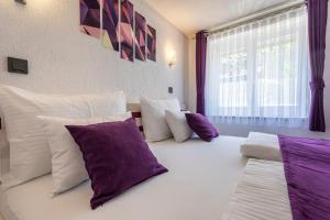 a bedroom with a large white bed with purple pillows at Villa Beganović in Krk +154 photos