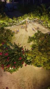 un chemin avec des bancs et des fleurs dans un parc dans l'établissement Island Break, à Fulidhoo