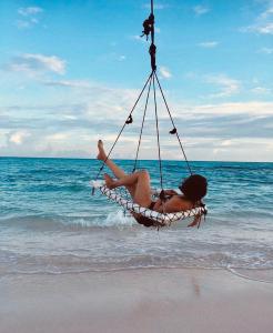 福里德霍的住宿－島嶼度假賓館，坐在海滩吊床上的女人