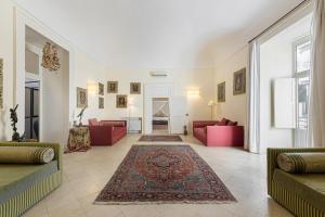 una sala de estar con 2 sofás rojos y una alfombra en Casa Bormioli - Maison de Charme, en Procida