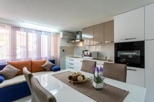 a kitchen and living room with a table and a couch at Villa Beganović in Krk
