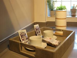 un plateau avec des tasses et des soucoupes sur une table dans l'établissement Cartref, à Farnham
