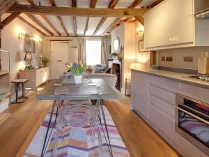 a kitchen and living room with a table and a couch at Cartref in Farnham