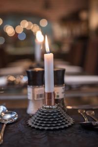 a candle sitting on top of a table with spoons at Alte Brucke Holiday Resort in Swakopmund