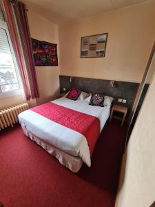 - une chambre avec un grand lit et une couverture rouge dans l'établissement HOSTELLERIE du CANTAL, à Murat