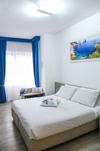 um quarto com uma grande cama branca com cortinas azuis em Al Parco II Rota B&B em Sorrento