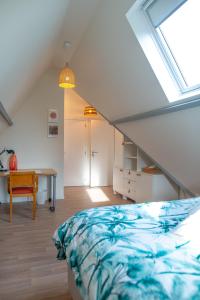 a bedroom with a bed and a desk and a window at DC's Home in Meise