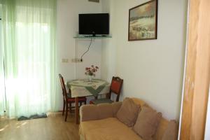 a living room with a couch and a table at Apartmani Mijatović in Lopar