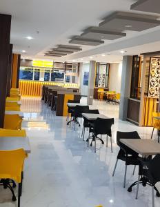 a dining room with tables and chairs in a restaurant at D'Carol Hotel in Surabaya