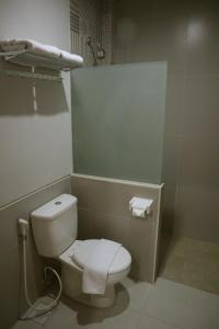 a bathroom with a white toilet and a shower at D'Carol Hotel in Surabaya