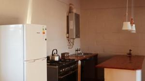 cocina con nevera blanca y fogones en Riverstone Game Farm, en Ladismith
