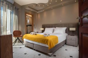 a bedroom with a large bed with a yellow blanket at Angelica's Deluxe Rooms in Adamas in Adamas