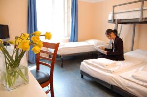 Eine Frau auf einem Bett in einem Hotelzimmer in der Unterkunft Pegasus Hostel Berlin in Berlin