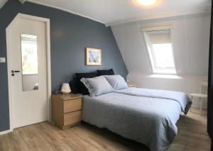 a bedroom with a large bed and a mirror at Vakantiehuis Sonnewende in Veere