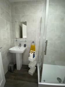 a small bathroom with a sink and a shower at Paisley Central Apartment #4 in Paisley