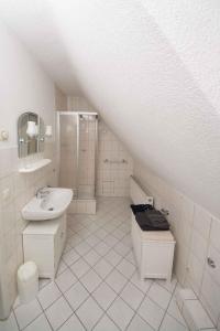 a white bathroom with a sink and a toilet at Ferienhaus Lütsche in Frankenhain +29 photos