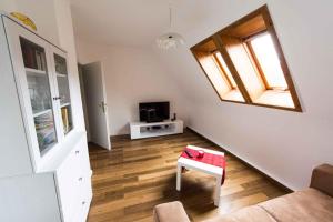 a living room with a staircase with a tv and a table at Ferienhaus Lütsche in Frankenhain