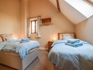 two twin beds in a room with a window at Granary, Oosland Farm in Bidford