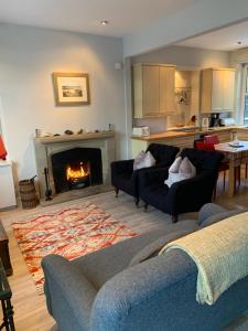 a living room with two couches and a fireplace at Tigh Beg Croft in Lerags