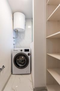 a washer and dryer in a white laundry room at Villa Beganović in Krk