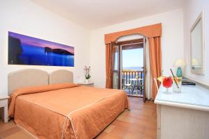 a hotel room with a bed and a balcony at Hotel Punta Negra in Alghero