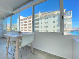 a table and chairs in a room with large windows at Cap Negret 15 in Altea
