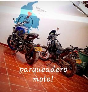 twee motorfietsen geparkeerd in een kamer met een kaart bij Family Host HOSTEL in Villa de Leyva