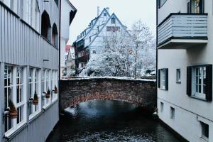 a bridge over a river between two buildings at Frevor - DESIGN L - I in Ulm